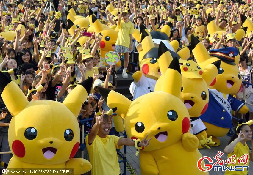 Dozens of people dressed up as Pikachu, the famous character of Nintendo's videogame software Pokemon, dance with fans as the final of a nine-day "Pikachu Outbreak" event takes place to attract summer vacationers in Yokohama, in suburban Tokyo, on August 16, 2015.       AFP PHOTO / Toru YAMANAKA
