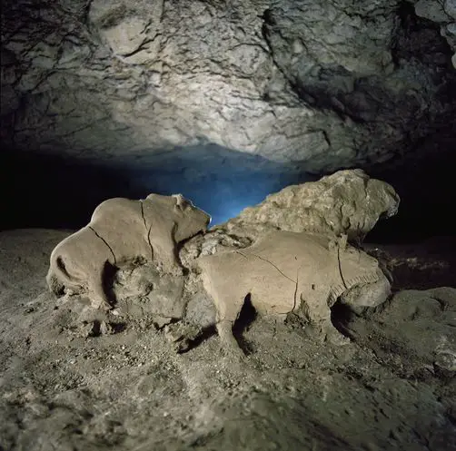 Deep in the subterranean recesses of the French Pyrenees, unknown hands shaped bison from moist clay 14,000 years ago. The early artists negotiated a river at the cave's entrance, then walked and crawled a kilometer to reach this secret placxe. From a clay deposit the sculptors cut a slab about a meter wide, leaned it against an outcrop, and modeled a male and female bison, along with a miniature bison since removed. Tuc d"audoubert cave was discovered in 1912.